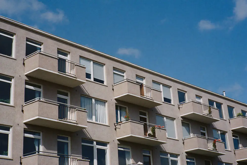 Appartementengebouw uit de jaren zeventig met balkons en rijen ramen