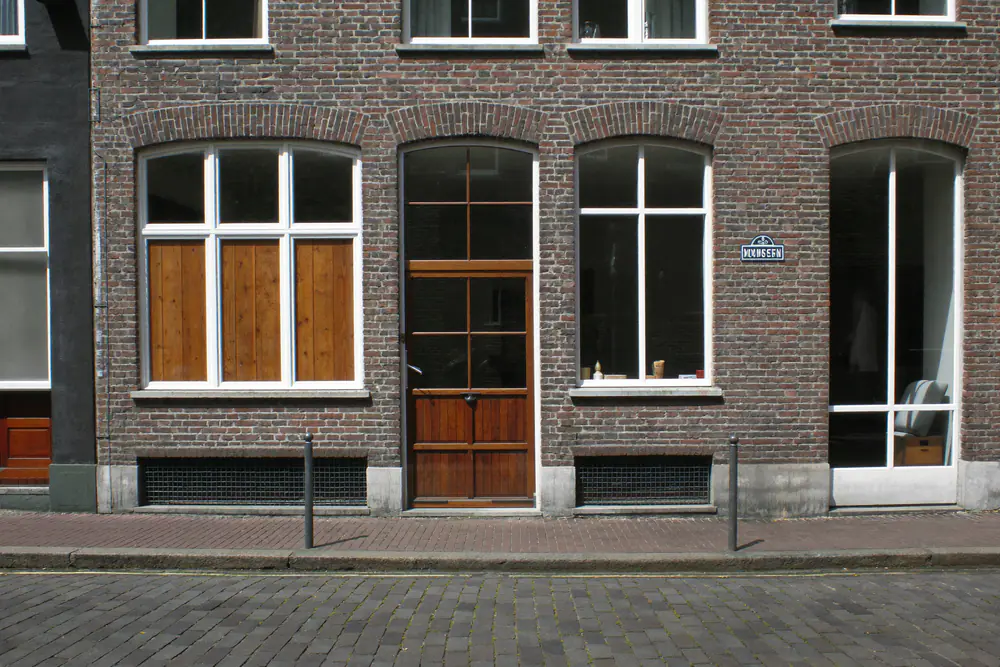 Statige gevel van een historisch pand in een binnenstad met hoge witte ramen