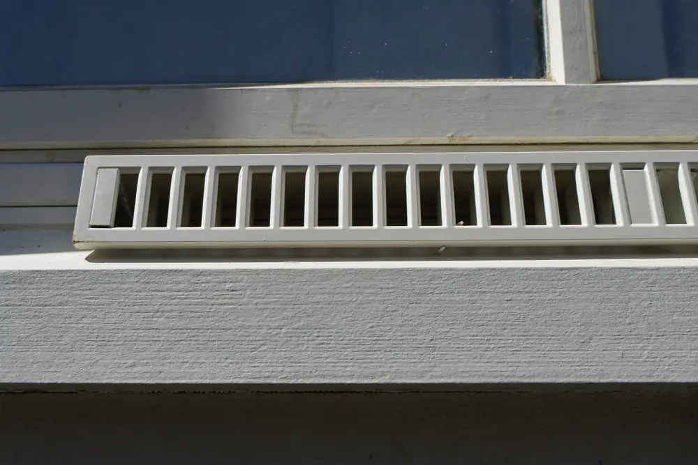 Ventilatierooster bovenin een kozijn van dichtbij
