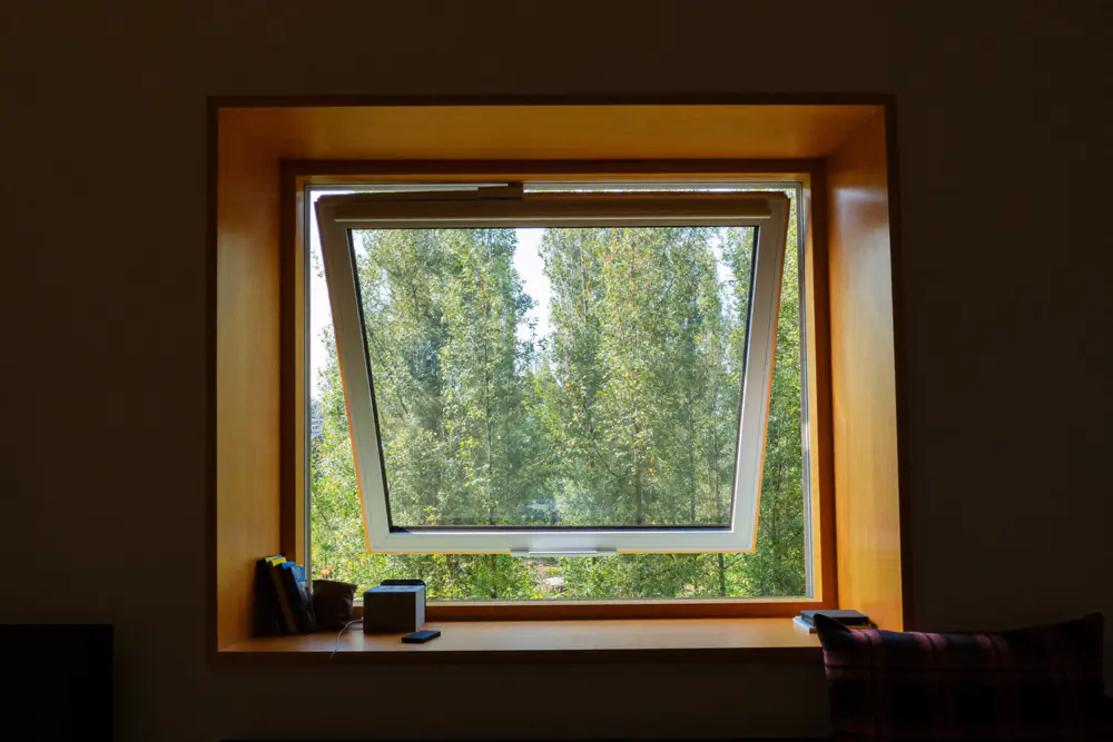 Houten binnenzijde van een hout-aluminium kozijn met uitzicht op bomen